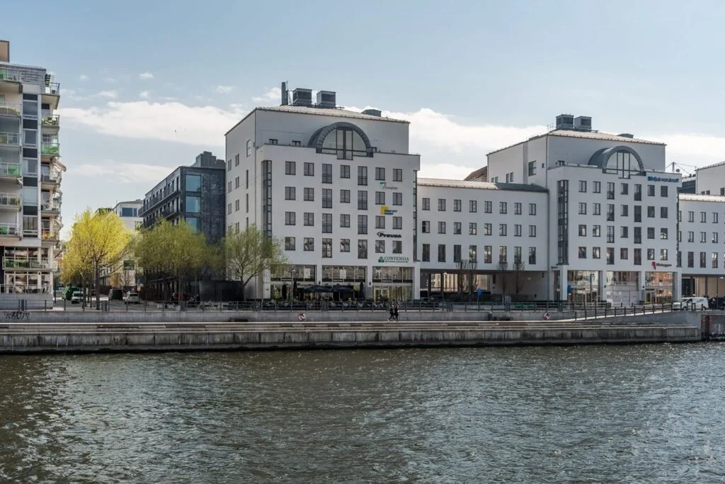 Waterfront office building in Stockholm with Complior signage on the facade.