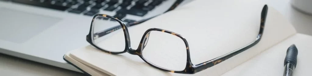 image of glasses on top of a laptop
