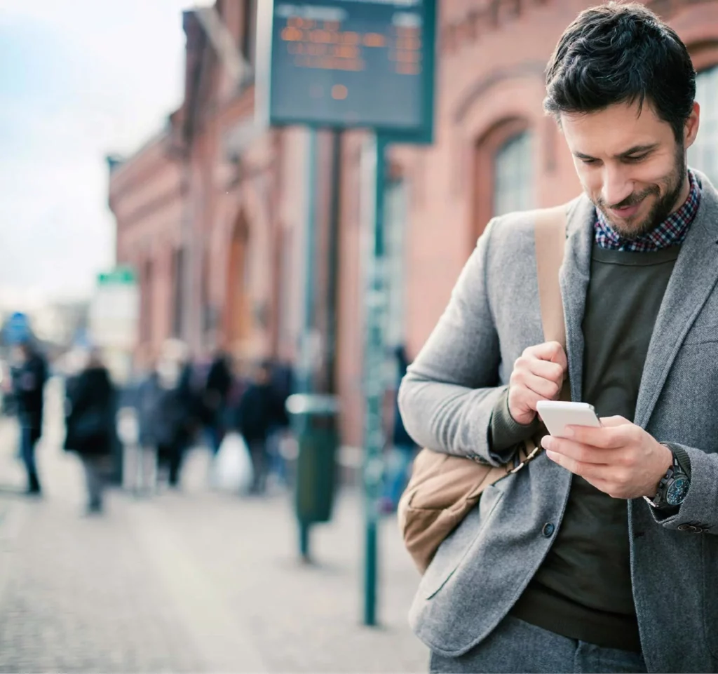 guy looking at phone on the street